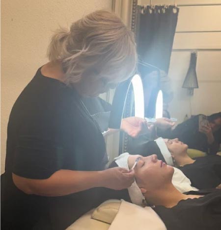 A student receiving hands-on facial training from an instructor, highlighting the individualized care and technical proficiency developed during the 600-hour esthetician program.